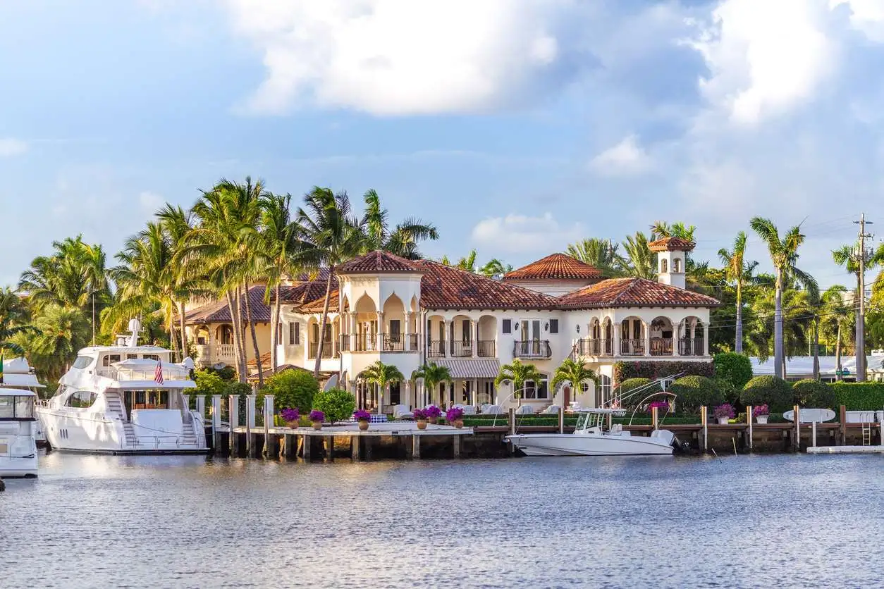 Luxury waterfront home with a private dock and yachts illustrating high-value home insurance coverage